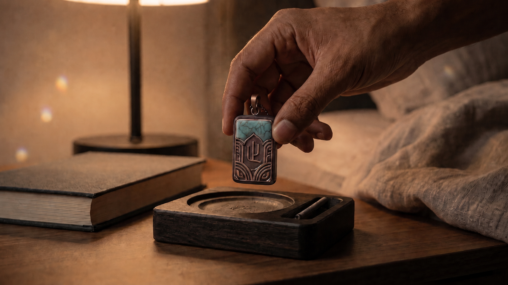 Hand returning the Stillpoint pendant to its resting base at night.